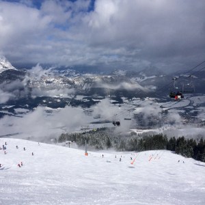Uitzicht na eerste afdaling. Piste met sneeuw en stoeltjeslift.