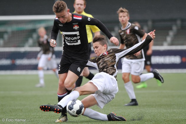 Speler van FC Dordrecht maakt sliding op de bal tegen Willem II U15